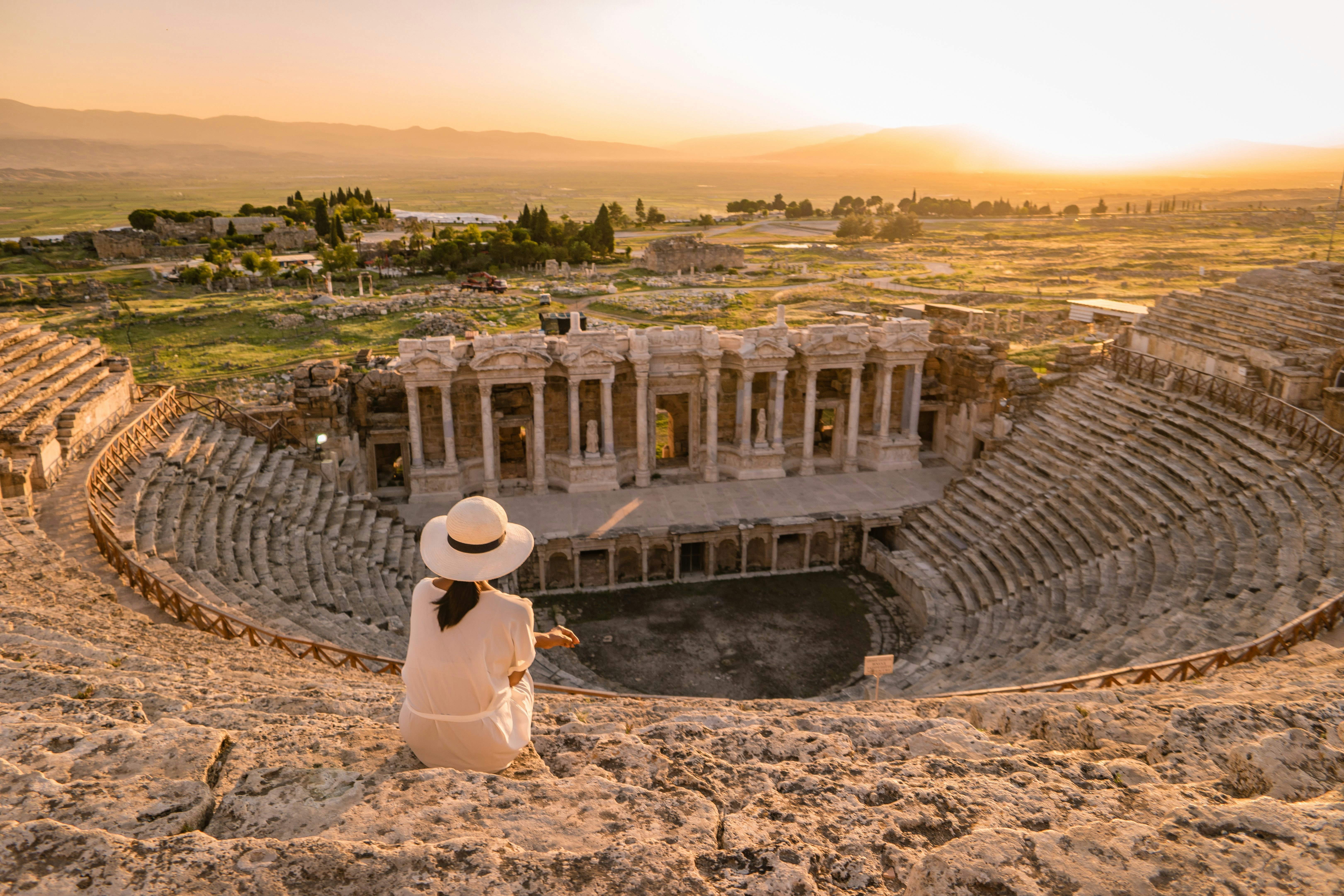 Hierapolis ancient city Pamukkale Turkey, young woman with hat watching sunset by the ruins Unesco ; Shutterstock ID 1167278944; your: Bridget Brown; gl: 65050; netsuite: Online Editorial; full: POI Image Update